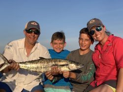 Family holding a fish they just caught