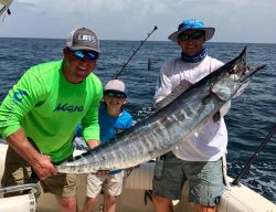 2 men and a boy pose with large fish